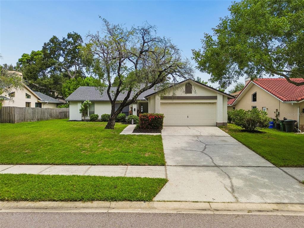 A single-story house with a white exterior, a two-car garage, and a front lawn — 525 WALKER ROAD, SAFETY HARBOR, FL