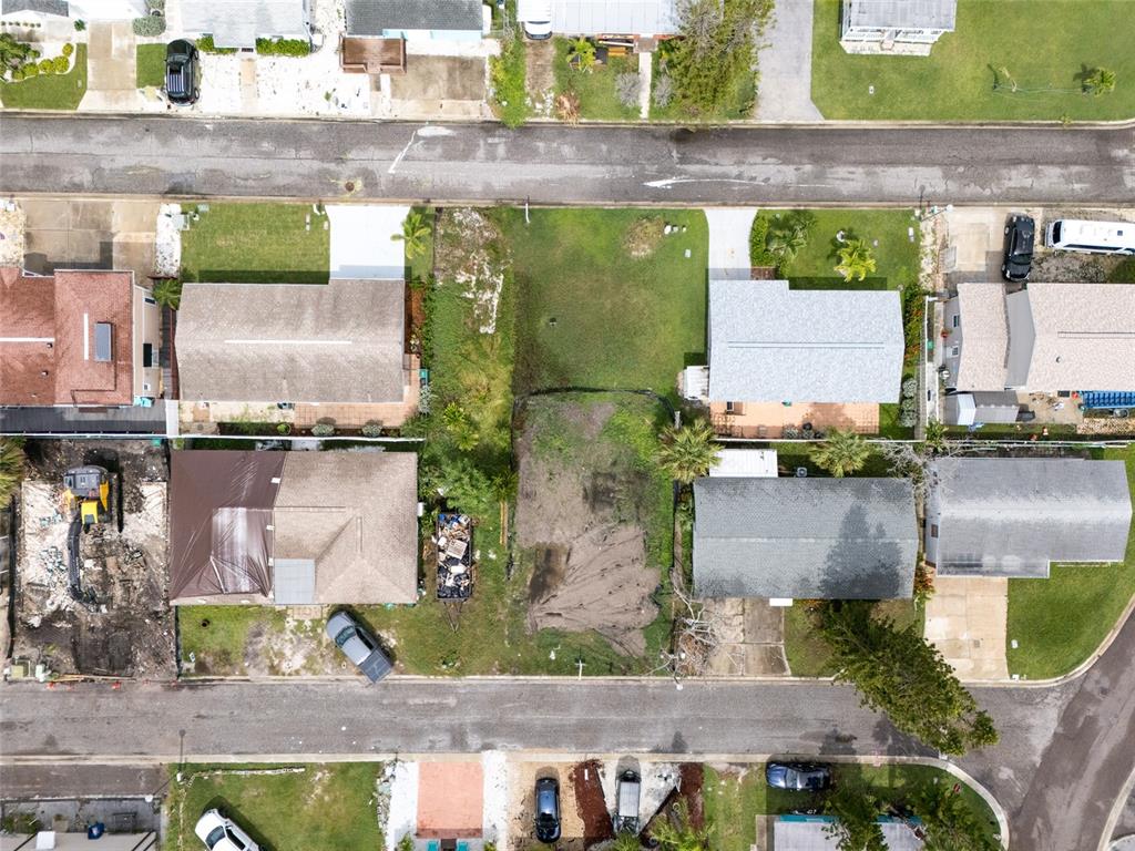 An aerial view shows several residential houses, a vacant lot, and streets with parked vehicles — 2ND STREET E, REDINGTON SHORES, FL