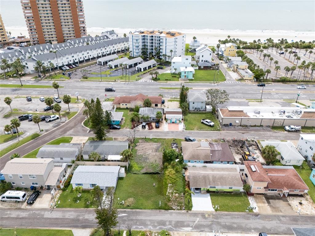 An aerial view shows residential houses, a vacant lot, and a beach in the background — 2ND STREET E, REDINGTON SHORES, FL