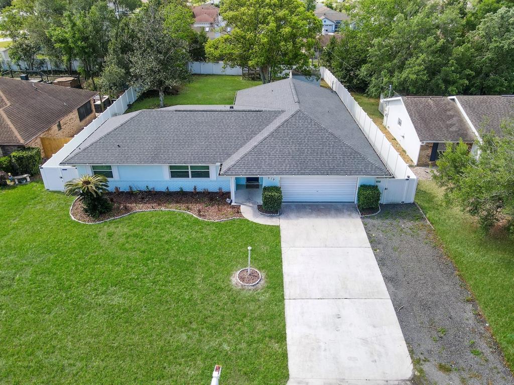 A single-story house with a light-colored exterior, a two-car garage, and a sunset sky — 919 SYLVIA DRIVE, DELTONA, FL