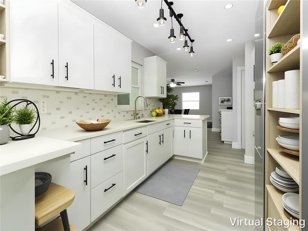 An open-concept living area features light gray wood-look flooring, white walls, and a modern light fixture — 919 SYLVIA DRIVE, DELTONA, FL