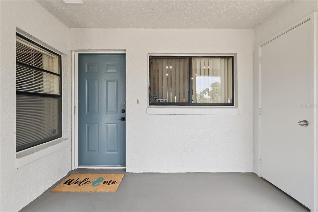 An entryway with tiled flooring leads down a hallway toward a living area with balcony — 1068 LOTUS PARKWAY UNIT 834, ALTAMONTE SPRINGS, FL
