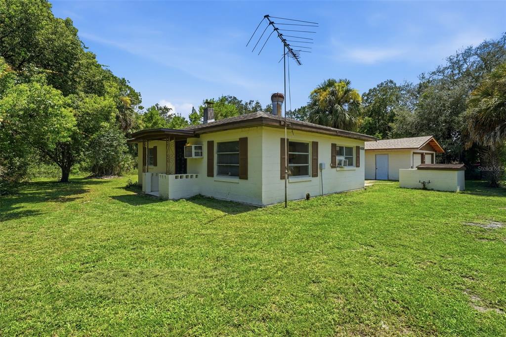 A light-colored, single-story house with a metal antenna and a detached garage in a yard — 45828 DEER STREET, PAISLEY, FL
