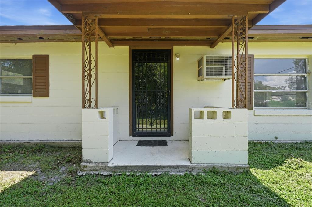 A front porch with a metal security door, concrete block walls, and decorative metal columns — 45828 DEER STREET, PAISLEY, FL