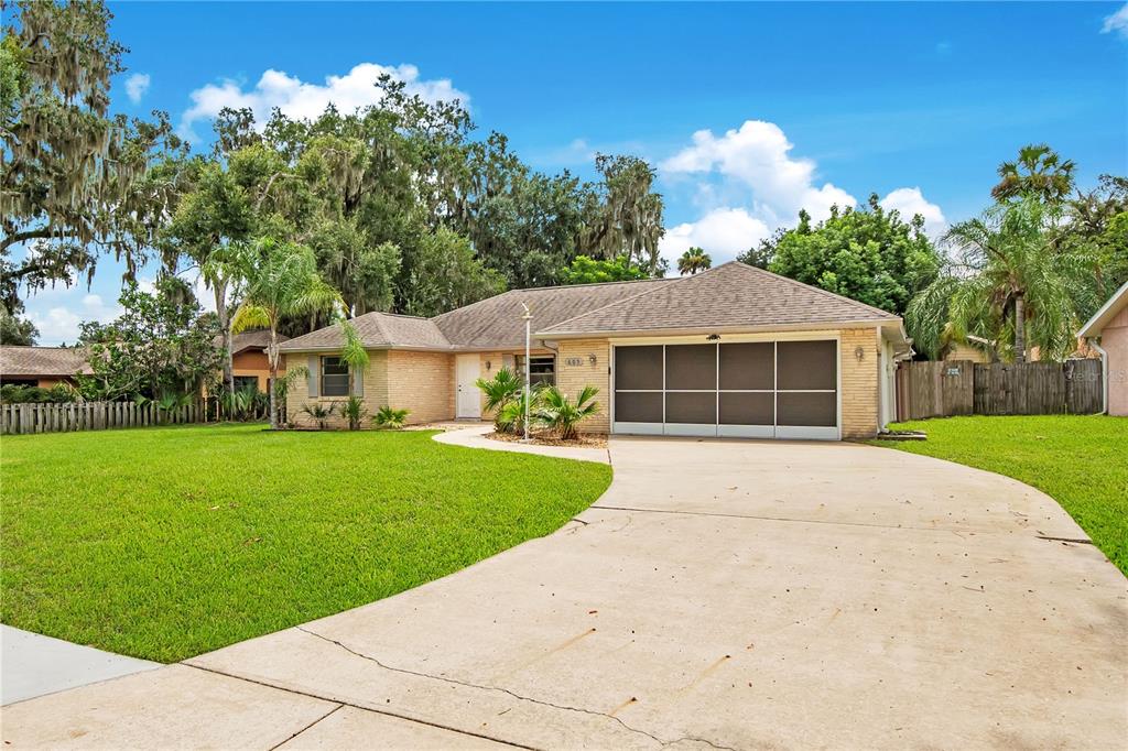 A single-story brick house with a screened garage and a concrete driveway — 605 BOARS HEAD DRIVE, PORT ORANGE, FL