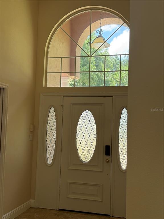 An entryway features a white front door with oval glass inserts and an arched transom window — 1760 LAKE TERRACE DR, EUSTIS, FL