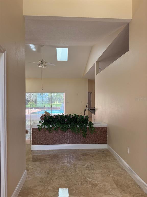A view from a hallway looking into a living area with tile floors and a pool — 1760 LAKE TERRACE DR, EUSTIS, FL