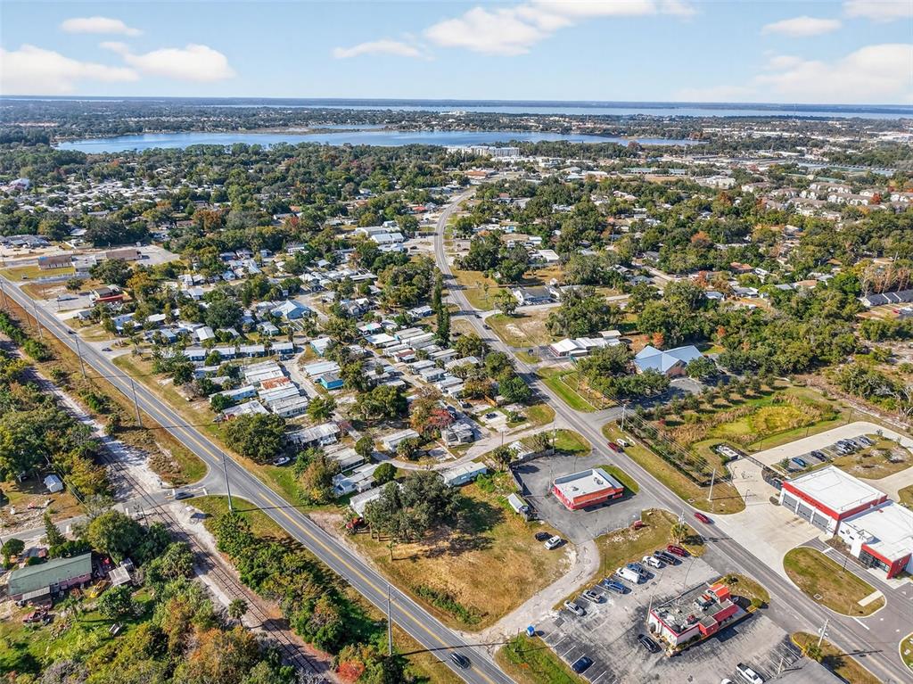 An aerial view shows a residential neighborhood with a commercial area and a nearby lake — OLD US-441 W, MOUNT DORA, FL
