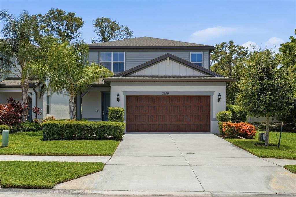 A two-story house with a grey exterior, a brown garage door, and a concrete driveway — 2949 PIER POINTE LANE, CLEARWATER, FL