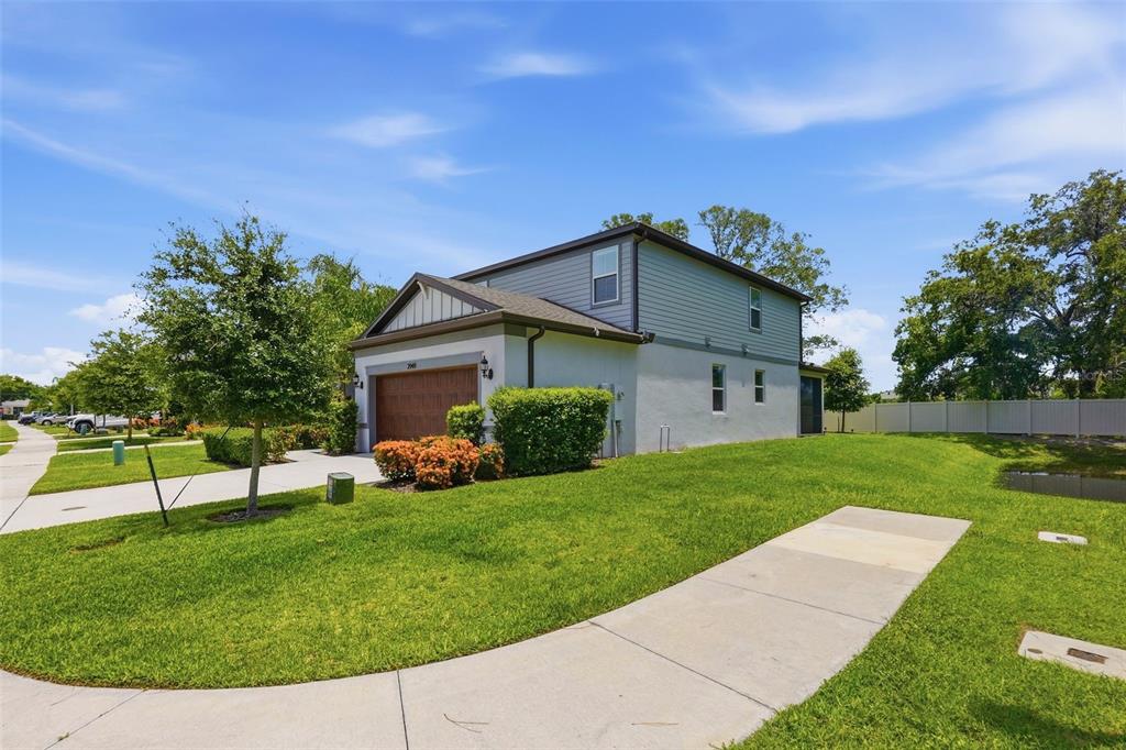 A two-story house with a brown garage door and gray siding sits on a lawn — 2949 PIER POINTE LANE, CLEARWATER, FL