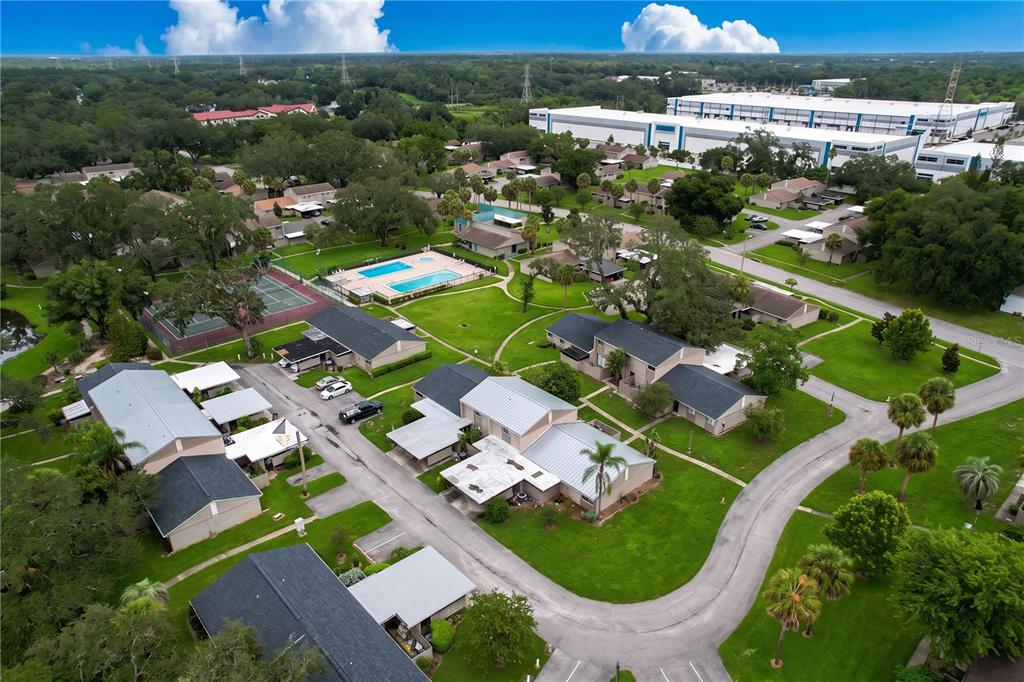 An aerial view shows a residential complex with townhouses, a swimming pool, and tennis courts — 7907 SABAL DRIVE, TEMPLE TERRACE, FL