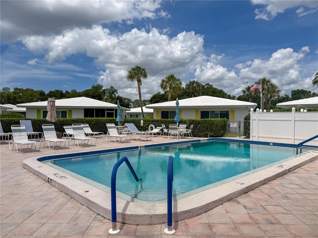 A white single-story house features a carport, a front lawn, and a window with shutters — 3816 ROXANE BLVD UNIT 158, SARASOTA, FL