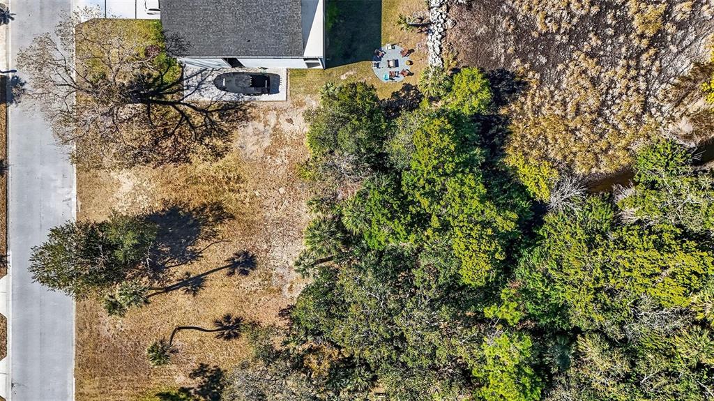 An aerial view shows a residential lot with a house, trees, and a backyard patio — 7657 GULF WAY, HUDSON, FL