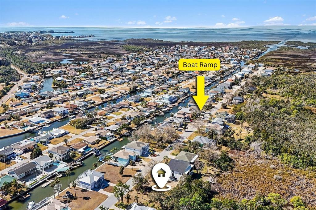 This aerial view shows a coastal residential neighborhood with canals and a marked boat ramp — 7657 GULF WAY, HUDSON, FL