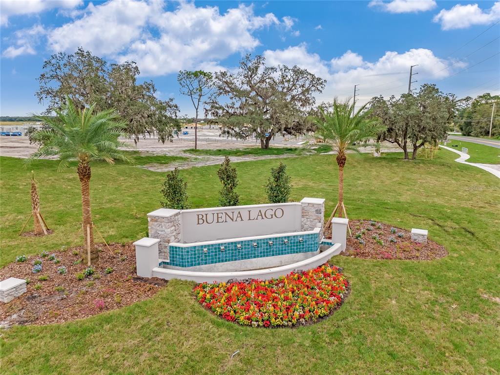 A stone and tile monument sign for Buena Lago sits in a landscaped grassy area — 3781 MALAWI TRAIL, ST CLOUD, FL