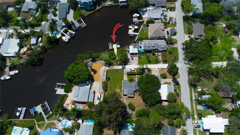A paved walkway leads through a grassy yard toward a wooden dock on the water — TENNESSEE AVENUE, CRYSTAL BEACH, FL