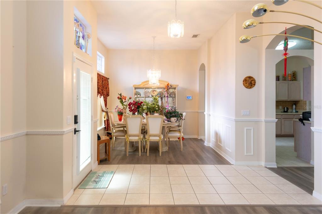 A dining room with a chandelier, a hutch, and a mix of tile and wood flooring — 1306 ISLAND COVE DRIVE, DELAND, FL