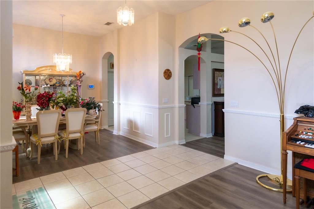 A dining room with a chandelier, tile flooring, and an arched entryway to another room — 1306 ISLAND COVE DRIVE, DELAND, FL