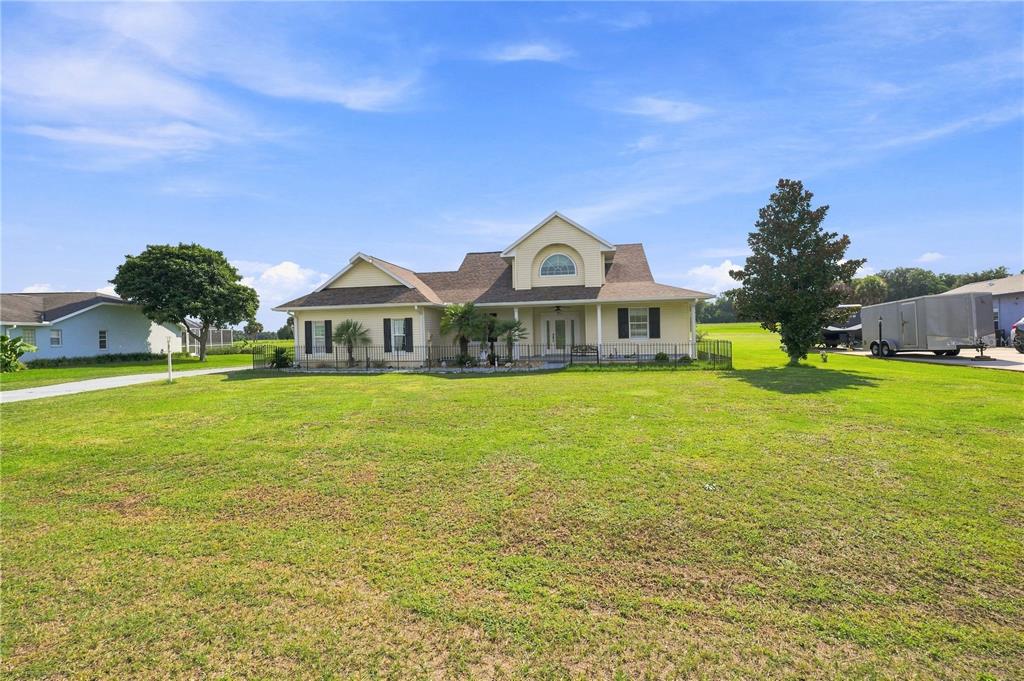A yellow two-story house with a front porch sits on a large grassy lot — 1375 TIMUCUAN, INVERNESS, FL
