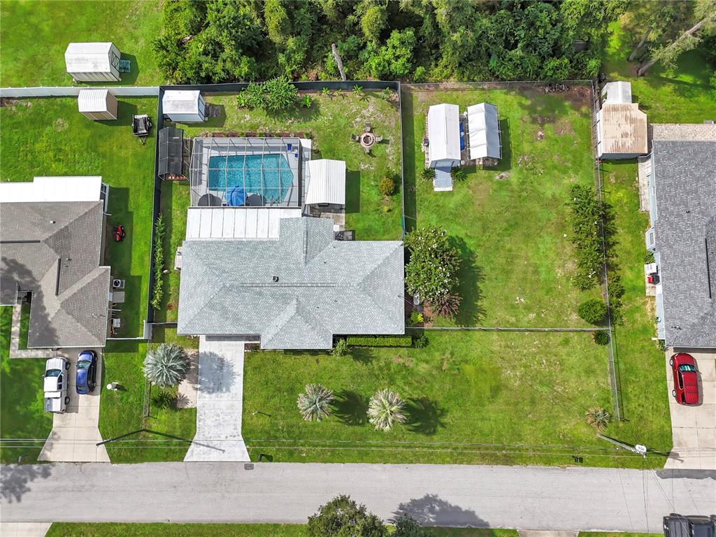 An aerial view shows a house with a pool, fenced yard, and several detached sheds — 6072 E RUSH STREET, INVERNESS, FL