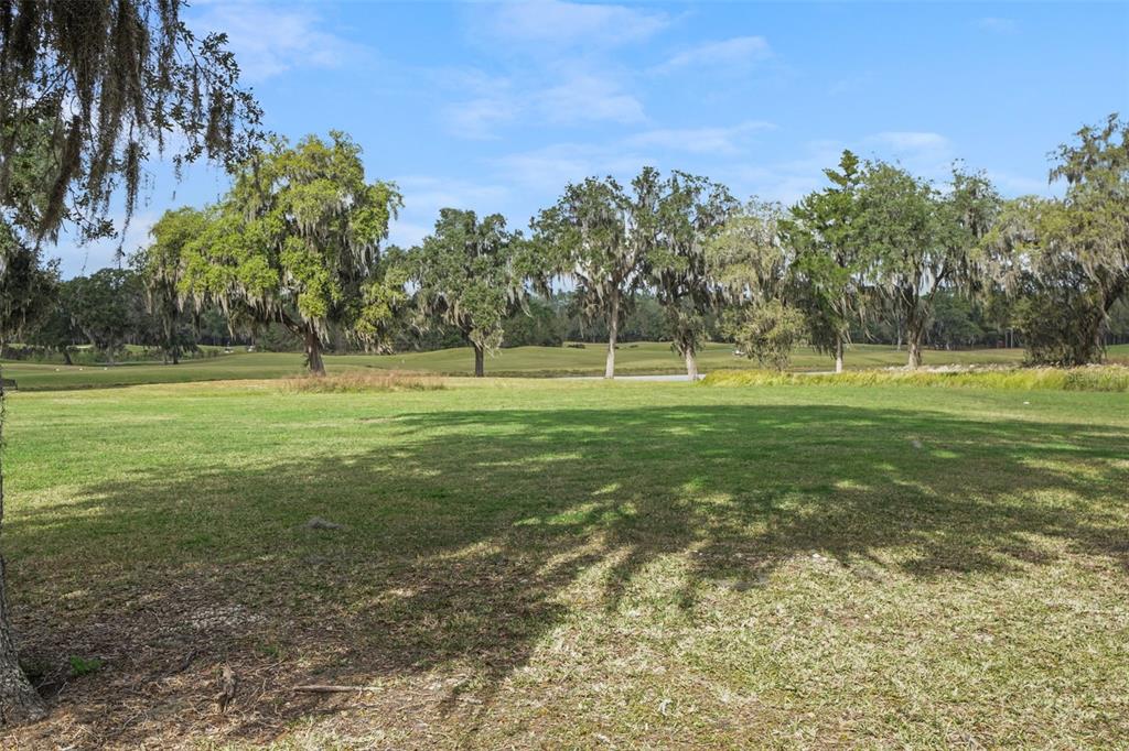 A covered concrete patio features a sliding glass door, outdoor seating, and a metal heater — 17807 GARSALASO CIRCLE, BROOKSVILLE, FL