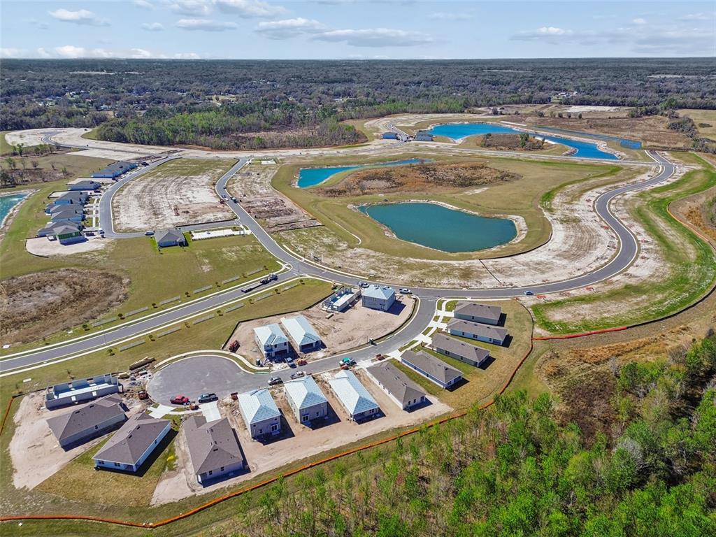 An aerial view shows a new residential development with several houses under construction near ponds — 4518 LAKE FOX DRIVE, LAKELAND, FL