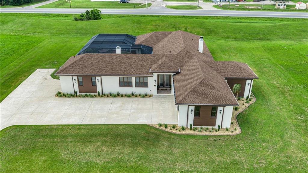 An aerial view shows a single-story house with a brown roof and a screened-in pool — 1866 NW 79TH LOOP, OCALA, FL