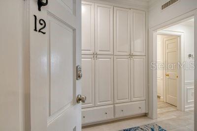 A white door with the number 12 opens to a hallway featuring built-in cabinetry — 51 MACEWEN DRIVE UNIT 12, OSPREY, FL
