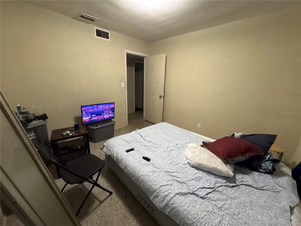 A bedroom features an air mattress, a small television on a bin, and a chair — 532 S CAROLINE STREET, DAYTONA BEACH, FL