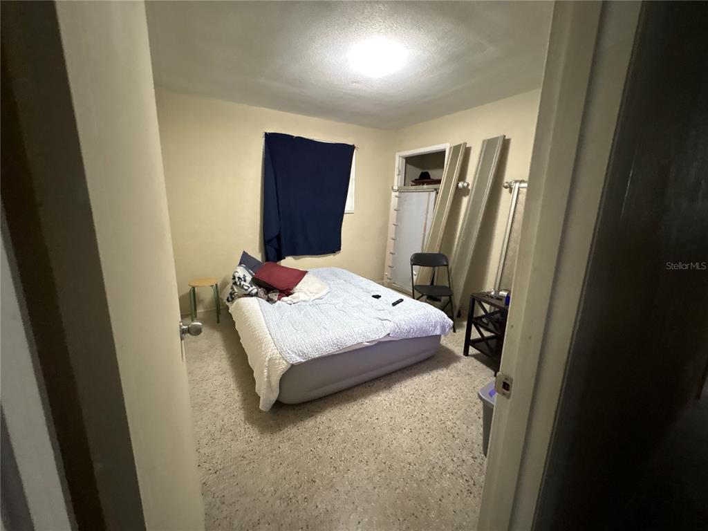 A bedroom features an air mattress, a small table, a folding chair, and a closet — 532 S CAROLINE STREET, DAYTONA BEACH, FL