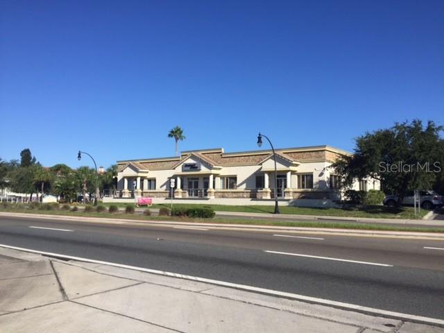 A single-story commercial building with a tan facade sits behind a road and sidewalk — 4811 W GANDY BOULEVARD UNIT A, TAMPA, FL