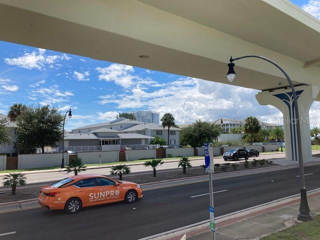 An orange Sunpro car drives on a road beneath a large concrete overpass — 4811 W GANDY BOULEVARD UNIT A, TAMPA, FL