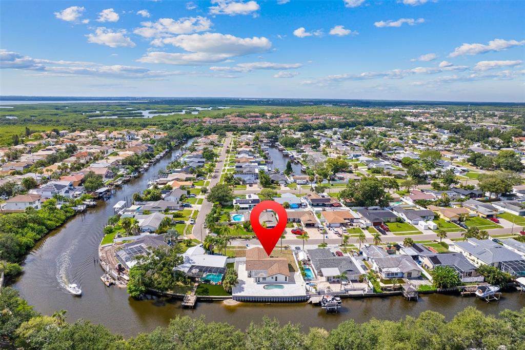 An aerial view shows a waterfront house with a pool and a red location pin — 5811 IMPERIAL KEY, TAMPA, FL