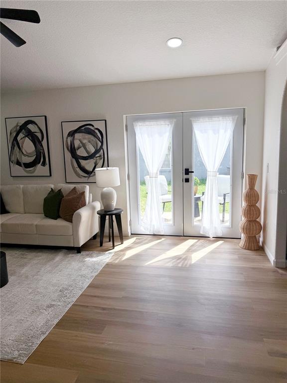 A living room features a white sofa, abstract wall art, and double glass doors — 1112 W 7TH STREET, SANFORD, FL