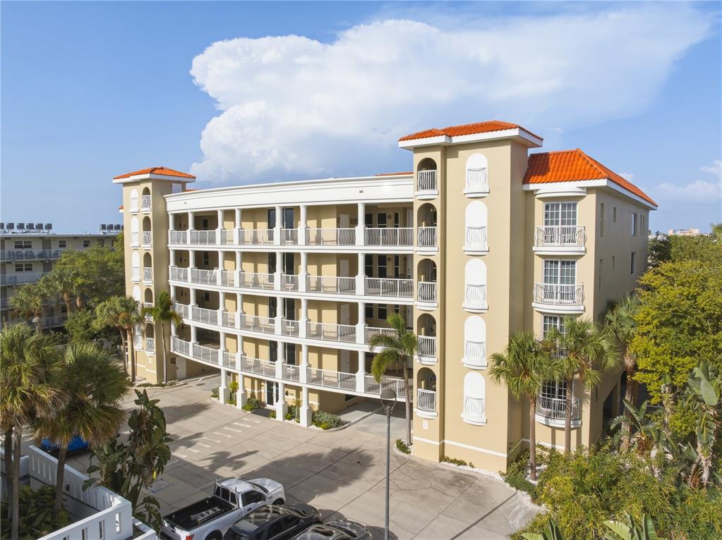 An aerial view shows a wide white sand beach bordering turquoise ocean waters and buildings — 3805 GULF BOULEVARD UNIT 203, ST PETE BEACH, FL