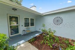 A light blue exterior wall features a front door, a window, and a decorative metal wheel — 1901 N LAKE ELOISE DRIVE, WINTER HAVEN, FL