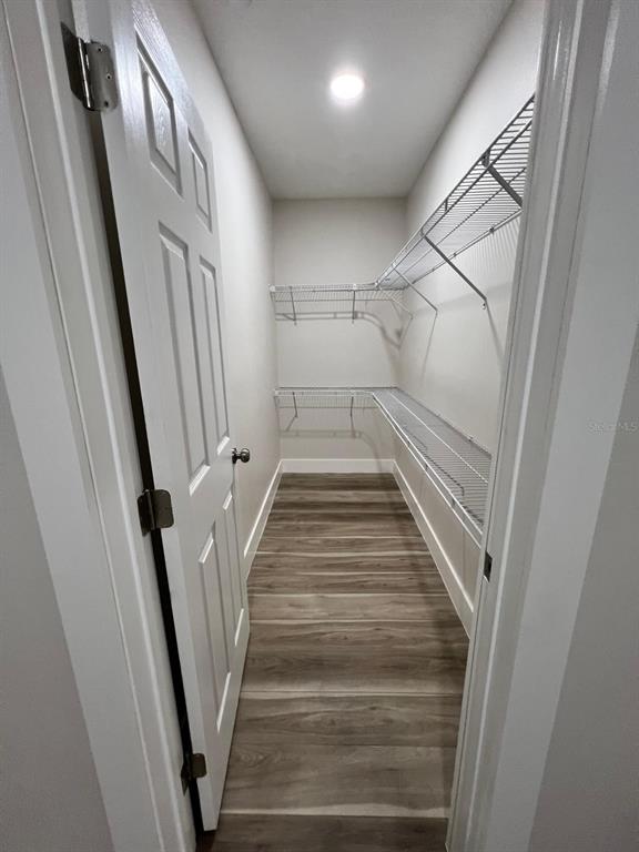 A walk-in closet features white walls, wood-look flooring, and tiered wire shelving — 475 UMATILLA BOULEVARD, UMATILLA, FL