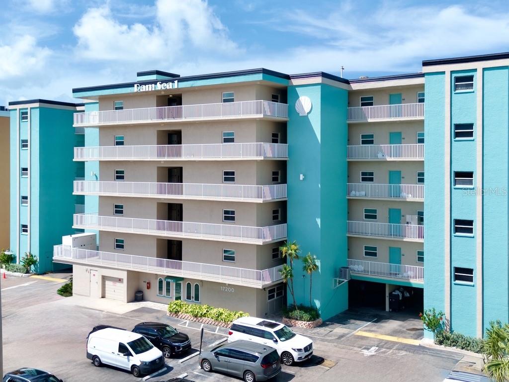 An elevated view of a white sand beach with blue umbrellas and palm trees — 17200 GULF BOULEVARD UNIT 202, NORTH REDINGTON BEACH, FL