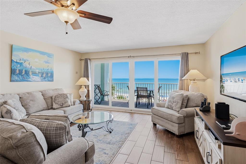 An elevated view of a beachside patio with tiki umbrellas, lounge chairs, and a hot tub — 17200 GULF BOULEVARD UNIT 202, NORTH REDINGTON BEACH, FL