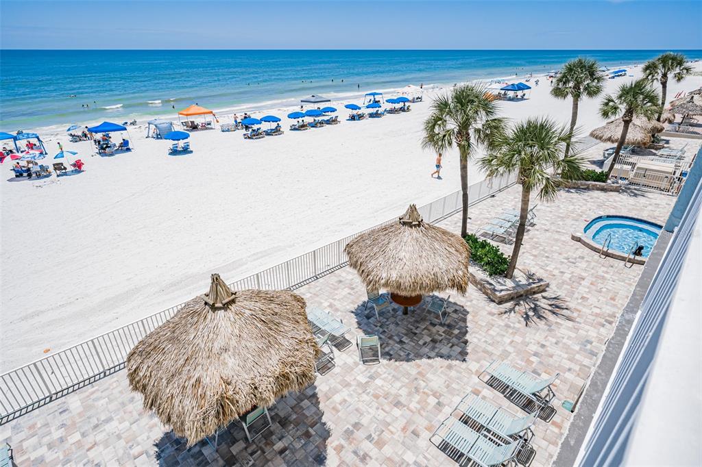 A balcony with a table and chairs overlooks a sandy beach and the ocean — 17200 GULF BOULEVARD UNIT 202, NORTH REDINGTON BEACH, FL