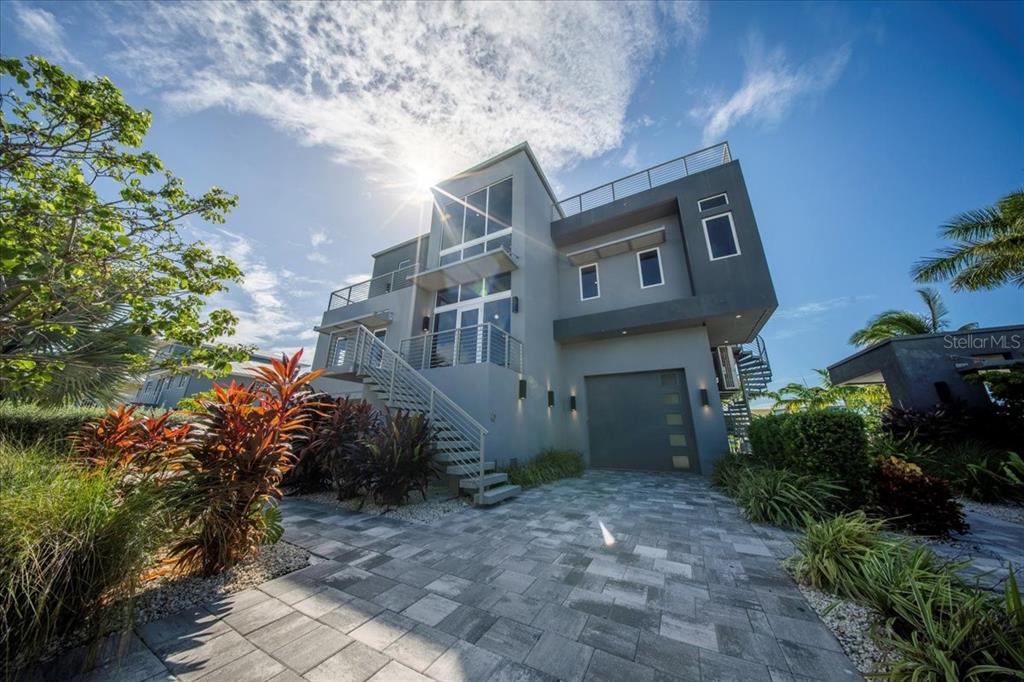 A modern three-story gray house with a paved driveway, exterior staircase, and rooftop deck — 118 AVENUE E, MARATHON, FL