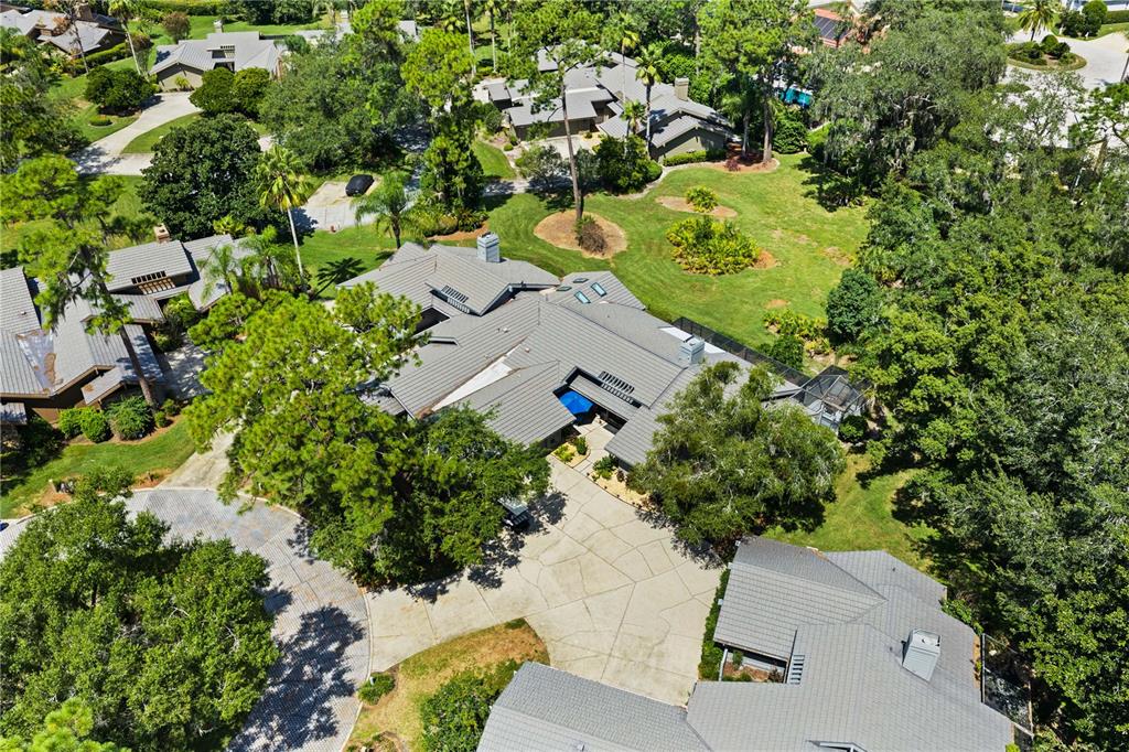 An aerial view shows a large house with a gray roof and a paved driveway — 5357 COBBLESTONE COURT, WESLEY CHAPEL, FL