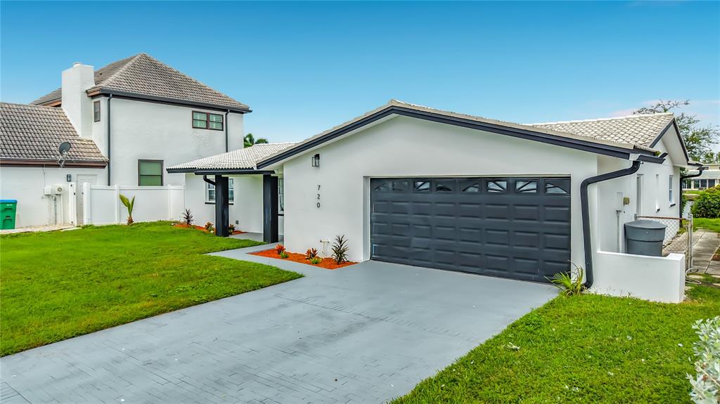 A modern kitchen with a black and white island sits in an open-concept living space — 720 CAPRI BOULEVARD, ST PETERSBURG, FL