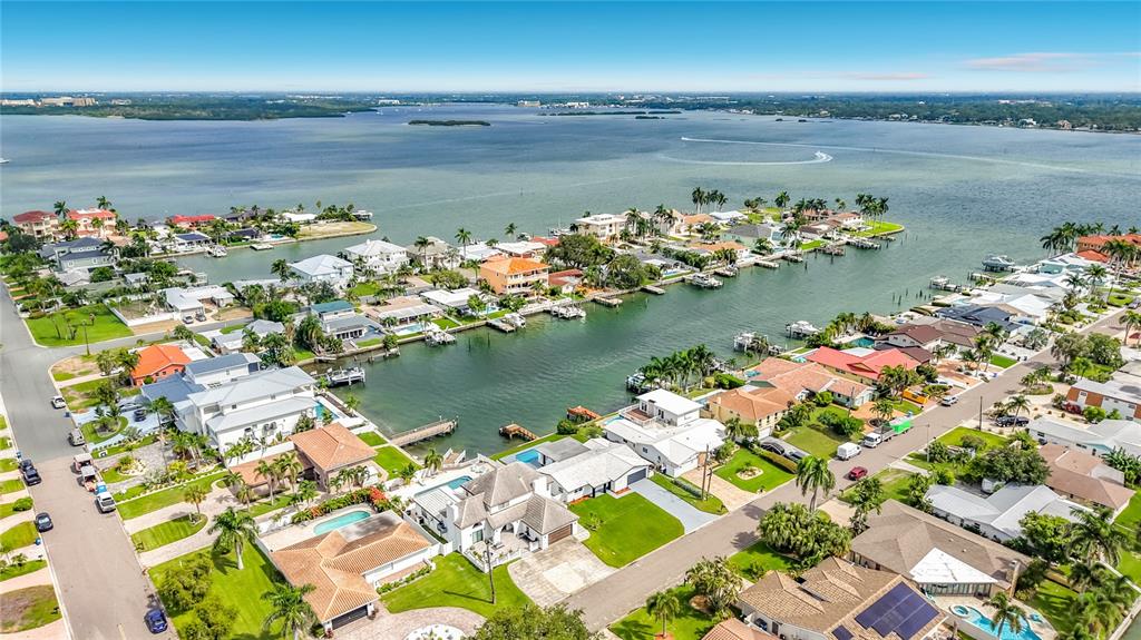 A kitchen with white cabinets, a black tiled backsplash, and a black-paneled island — 720 CAPRI BOULEVARD, ST PETERSBURG, FL