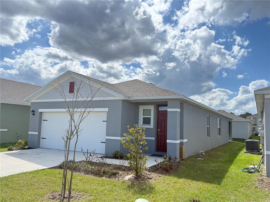 A single-story gray house with a white garage door and a red front door — 3732 GIORGIO DRIVE, WINTER HAVEN, FL