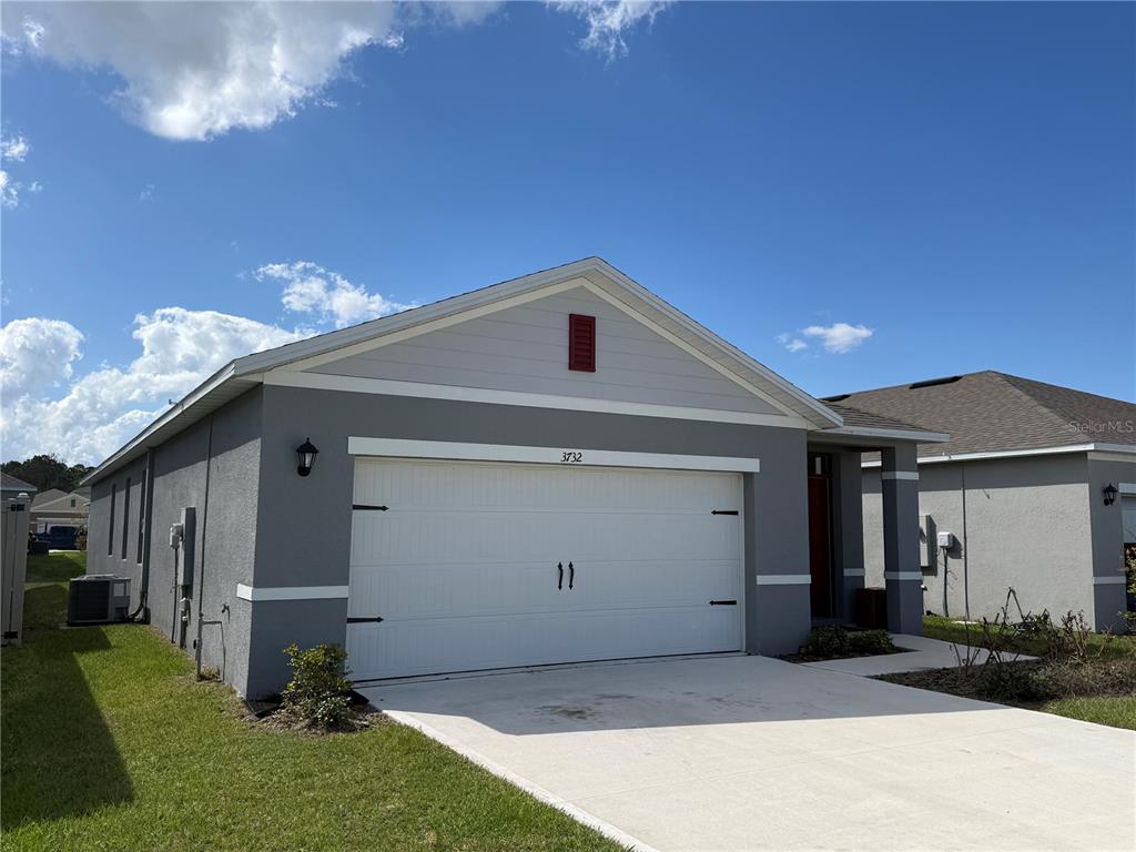 A gray single-story house with a two-car garage and a concrete driveway — 3732 GIORGIO DRIVE, WINTER HAVEN, FL