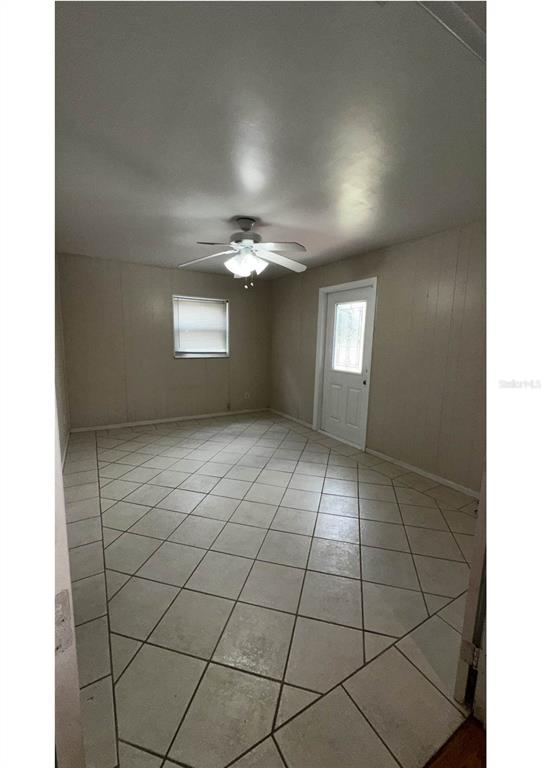 An empty room features hardwood floors, white plantation shutters, and a ceiling track lighting fixture — 2014 LINDA STREET, ORLANDO, FL