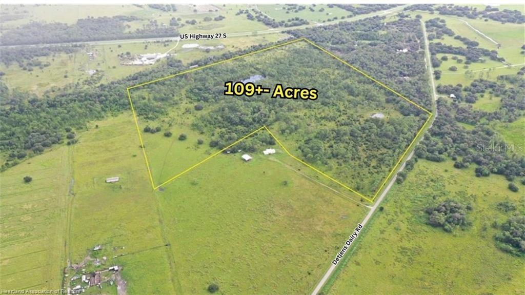 An aerial view shows a large, wooded plot of land outlined in yellow near roads — DETJENS DAIRY ROAD, VENUS, FL