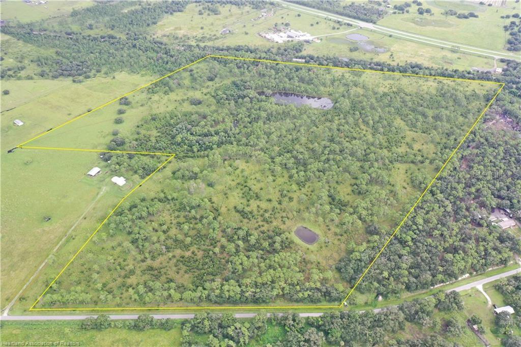 An aerial view shows a large, wooded plot of land outlined in yellow with two ponds — DETJENS DAIRY ROAD, VENUS, FL
