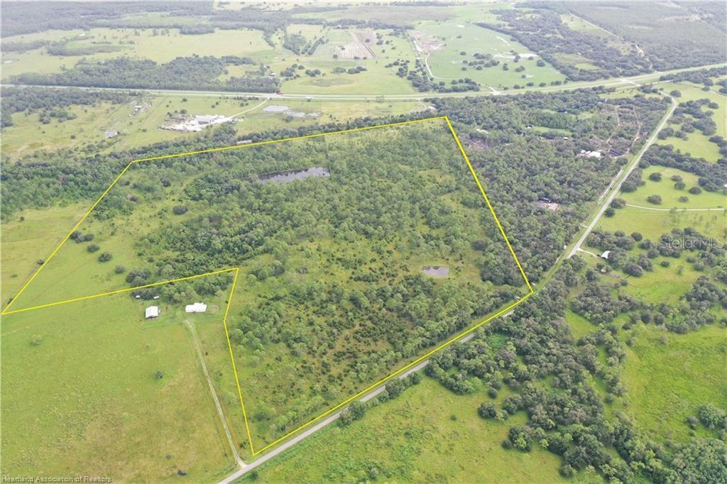 An aerial view shows a large, partially wooded plot of land outlined in yellow — DETJENS DAIRY ROAD, VENUS, FL